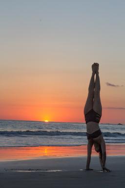 hand stand on the beach at sunset