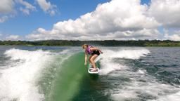 a woman wakesurfing on a sunny day on lake arenal