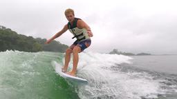 a man wakesurfs on lake arenal in the morning