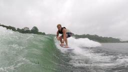 a man surfs the wake on lake arenal