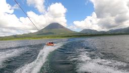 a couple of friends tubing on lake arenal with the view of the volcano