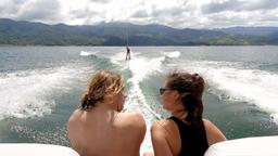 friends watching a third one waterskiing on lake arenal