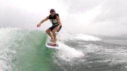 a man wakesufing on lake arenal in a rainy morning
