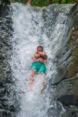 man sliding on uvita waterfall waterfall tour manuel antonio