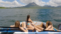 friends admiring the view of arenal volcano from the boat
 - Costa Rica