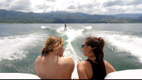 friends watching a third one waterskiing on lake arenal
 - Costa Rica