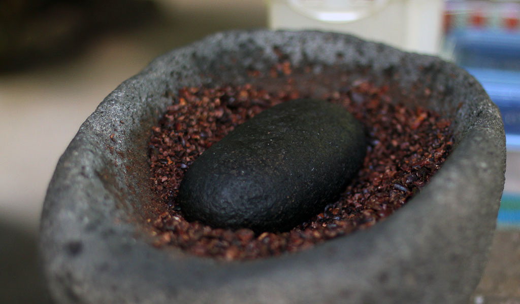 tirimbina grinding cocoa by hand
 - Costa Rica